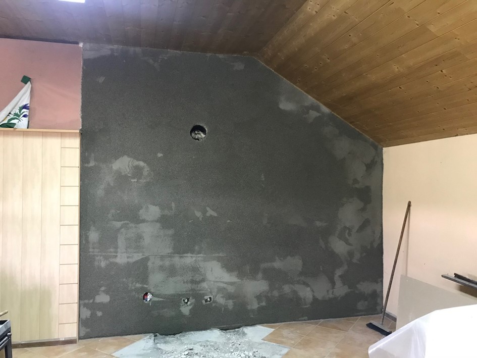 Die verputzte Wand mit dem auszubessernden Fussboden